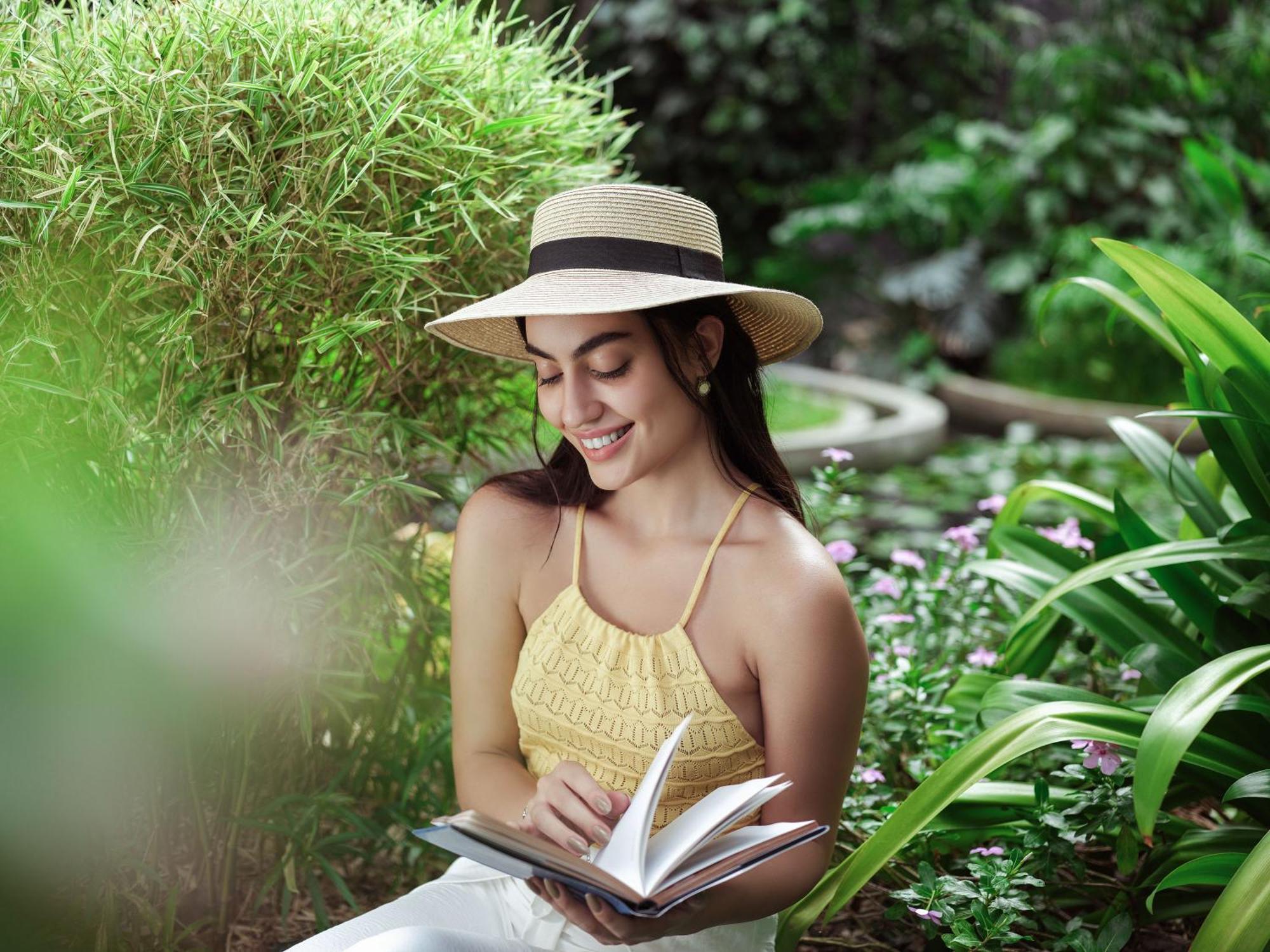 Отель Taj Krishna Хайдарабад Экстерьер фото A woman reading a book in a garden